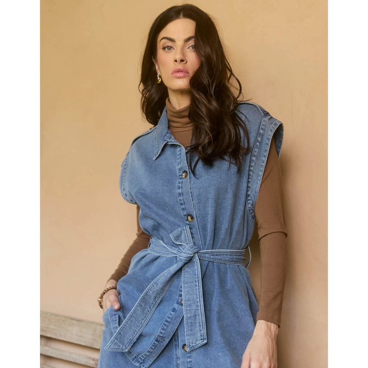 &nbsp;Freya Vest- Denim

Bold yet sophisticated, the Freya Vest redefines seasonal layering with its premium cotton-blend construction and striking design. The full button-down front is complemented by a sharp collar, cap sleeves, and a removable self-fabric belt, offering a tailored silhouette when desired. Whether left open or cinched at the waist, this vest adds a polished finish to any neutral ensemble.