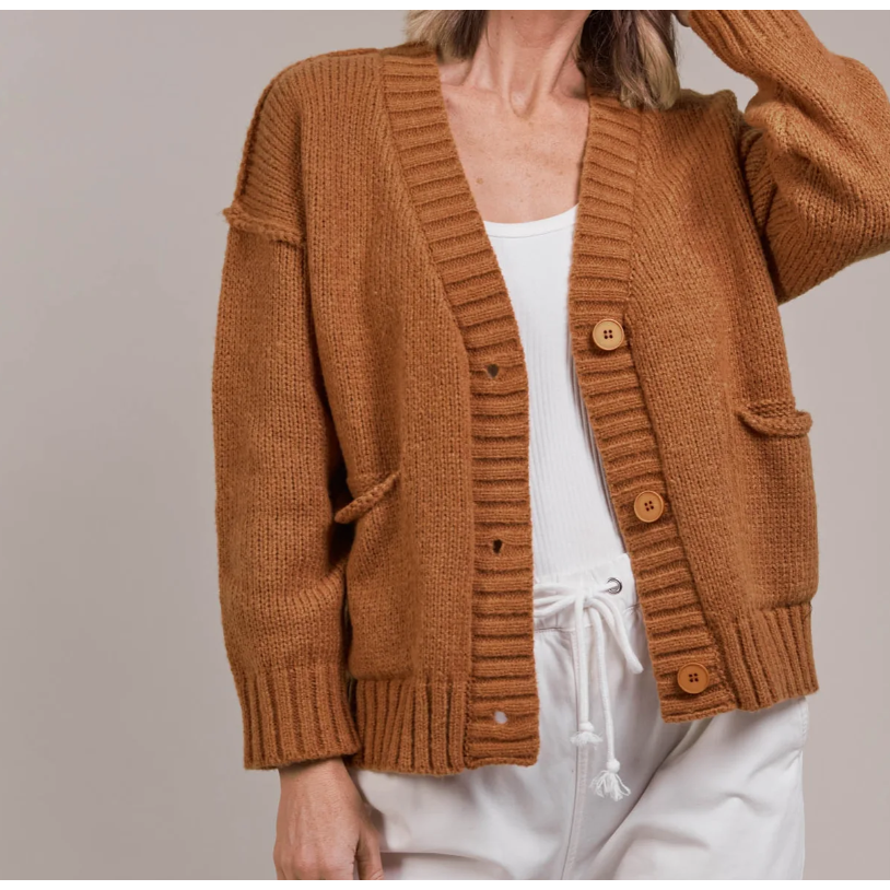 Katana Cardigan

For easy off-duty style, the Katana Cardigan is a perfect pick. Made from plush recycled polyester, this soft knit offers a classic V-neckline with a three-button front and bold ribbed detailing. A true transeasonal essential, it seamlessly complements your wardrobe basics. Style it with denim for a comfortable yet chic look.
