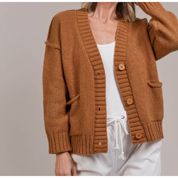 Katana Cardigan

For easy off-duty style, the Katana Cardigan is a perfect pick. Made from plush recycled polyester, this soft knit offers a classic V-neckline with a three-button front and bold ribbed detailing. A true transeasonal essential, it seamlessly complements your wardrobe basics. Style it with denim for a comfortable yet chic look.