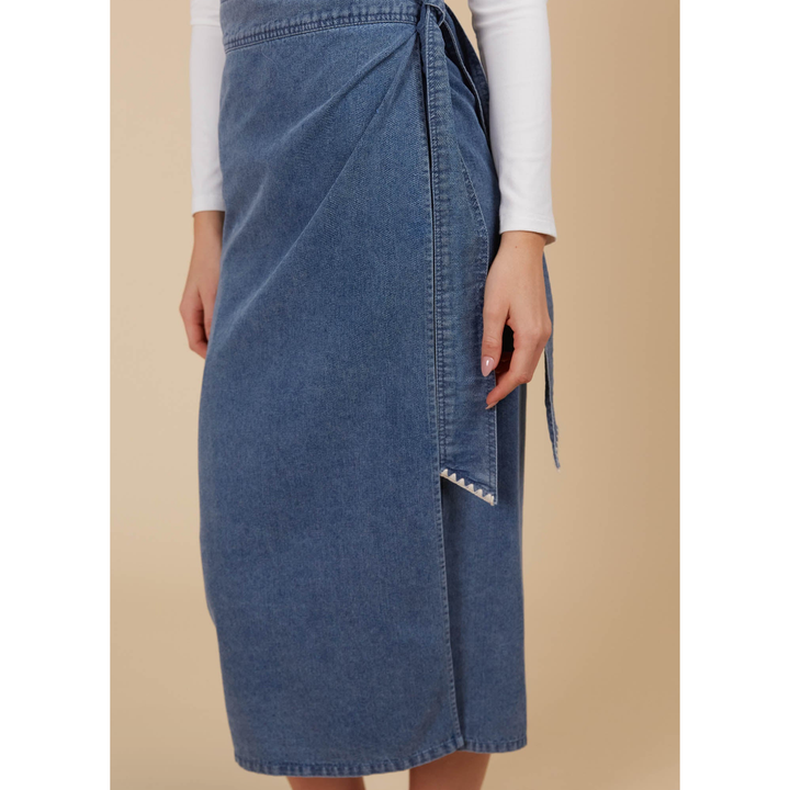 Freya Wrap Skirt -Denim

The Freya Wrap Skirt is destined to be a staple in your winter collection. With its graceful midi length and tailored wrap design, it strikes a balance between sophistication and versatility. The high-rise fit is cinched with a self-fabric belt, creating a streamlined profile that complements any setting. Style it with a long-sleeve top, sleek knee-high boots, and a classic trench coat for a chic ensemble that works from morning to evening.