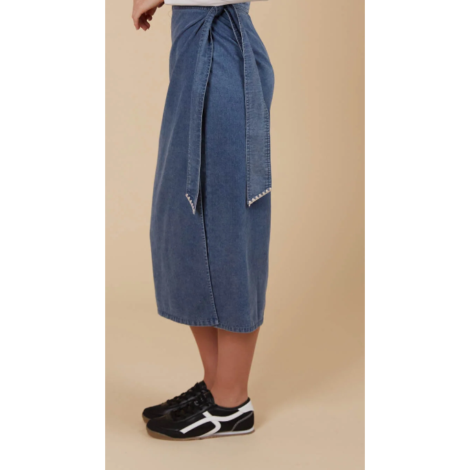 Freya Wrap Skirt -Denim

The Freya Wrap Skirt is destined to be a staple in your winter collection. With its graceful midi length and tailored wrap design, it strikes a balance between sophistication and versatility. The high-rise fit is cinched with a self-fabric belt, creating a streamlined profile that complements any setting. Style it with a long-sleeve top, sleek knee-high boots, and a classic trench coat for a chic ensemble that works from morning to evening.