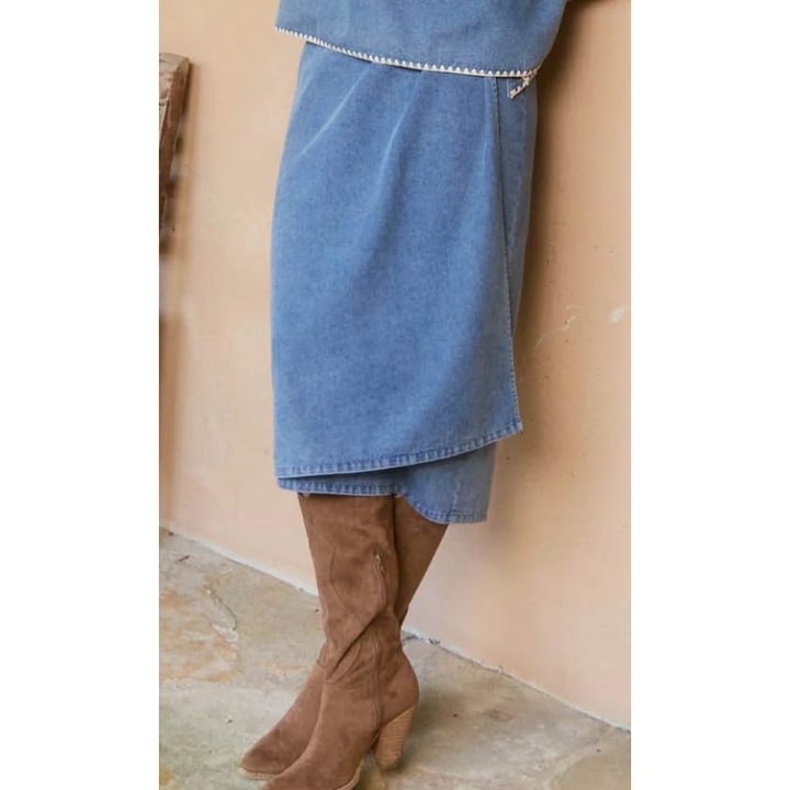 Freya Wrap Skirt -Denim

The Freya Wrap Skirt is destined to be a staple in your winter collection. With its graceful midi length and tailored wrap design, it strikes a balance between sophistication and versatility. The high-rise fit is cinched with a self-fabric belt, creating a streamlined profile that complements any setting. Style it with a long-sleeve top, sleek knee-high boots, and a classic trench coat for a chic ensemble that works from morning to evening.