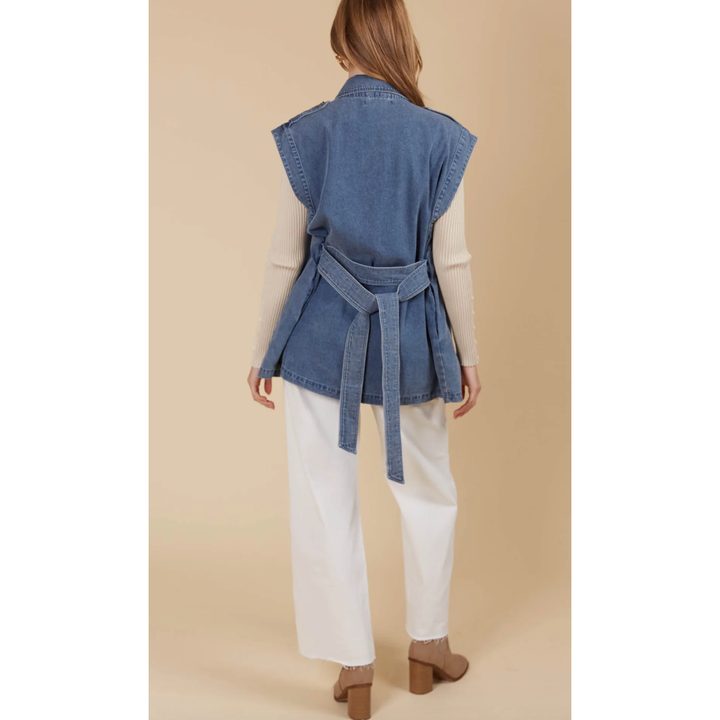 &nbsp;Freya Vest- Denim

Bold yet sophisticated, the Freya Vest redefines seasonal layering with its premium cotton-blend construction and striking design. The full button-down front is complemented by a sharp collar, cap sleeves, and a removable self-fabric belt, offering a tailored silhouette when desired. Whether left open or cinched at the waist, this vest adds a polished finish to any neutral ensemble.