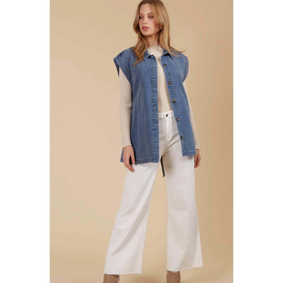 &nbsp;Freya Vest- Denim

Bold yet sophisticated, the Freya Vest redefines seasonal layering with its premium cotton-blend construction and striking design. The full button-down front is complemented by a sharp collar, cap sleeves, and a removable self-fabric belt, offering a tailored silhouette when desired. Whether left open or cinched at the waist, this vest adds a polished finish to any neutral ensemble.